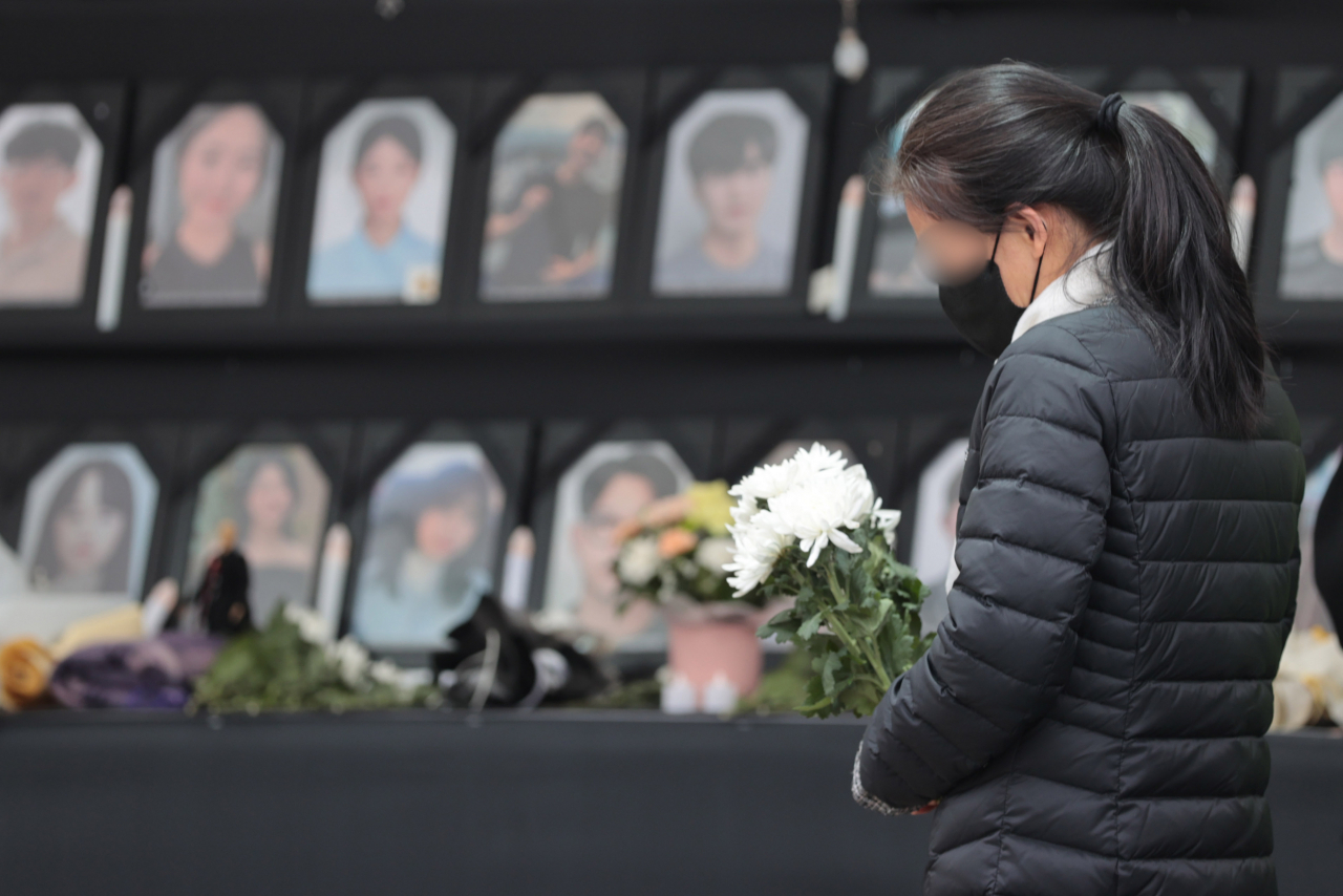 지난 18일 오전 서울 중구 서울광장에 설치된 10.29 이태원 참사 분향소에서 한 유족이 국화를 들고 있다. 서울시는 지난 15일 오후 1시까지 분향소를 자진 철거하라며 통보했으나 유족 측은 분향소를 유지하겠다는 입장을 밝혔다. [연합]
