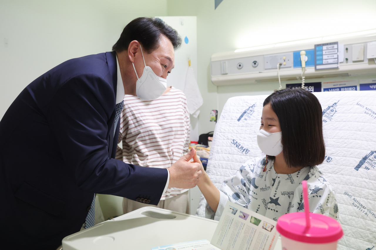 윤석열 대통령이 22일 서울 종로구 서울대학교어린이병원 소아외과 병동을 방문, 입원 중인 어린이와 보호자를 격려하고 있다. [연합]