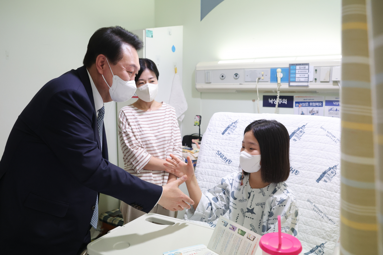 윤석열 대통령이 22일 서울 종로구 서울대학교어린이병원 소아외과 병동을 방문, 입원 중인 어린이와 보호자를 격려하고 있다. [연합]