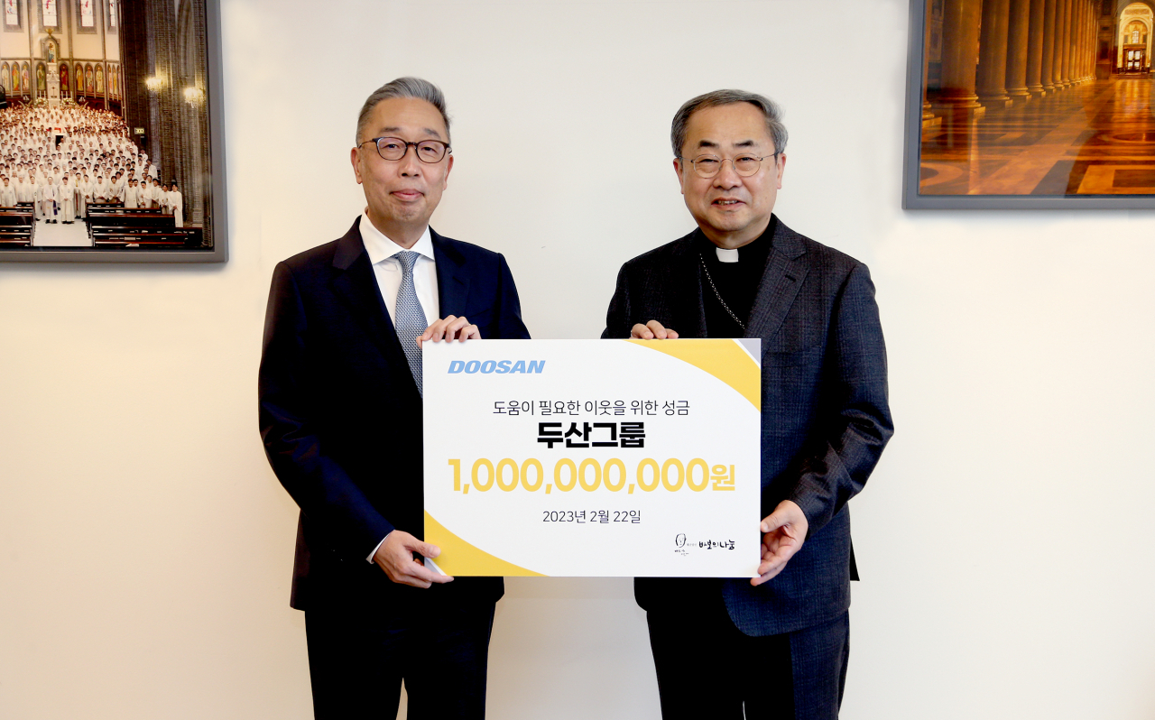 22일 명동성당에서 열린 성금 전달식에서 박지원 두산그룹 부회장(왼쪽)과 손희송 재단법인 바보의 나눔 이사장이 기념촬영을 하고 있다. [두산 제공]