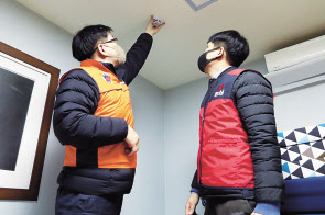 농심 직원(오른쪽)과 소방대원이 화재경보기를 설치하고 있다. [농심 제공]