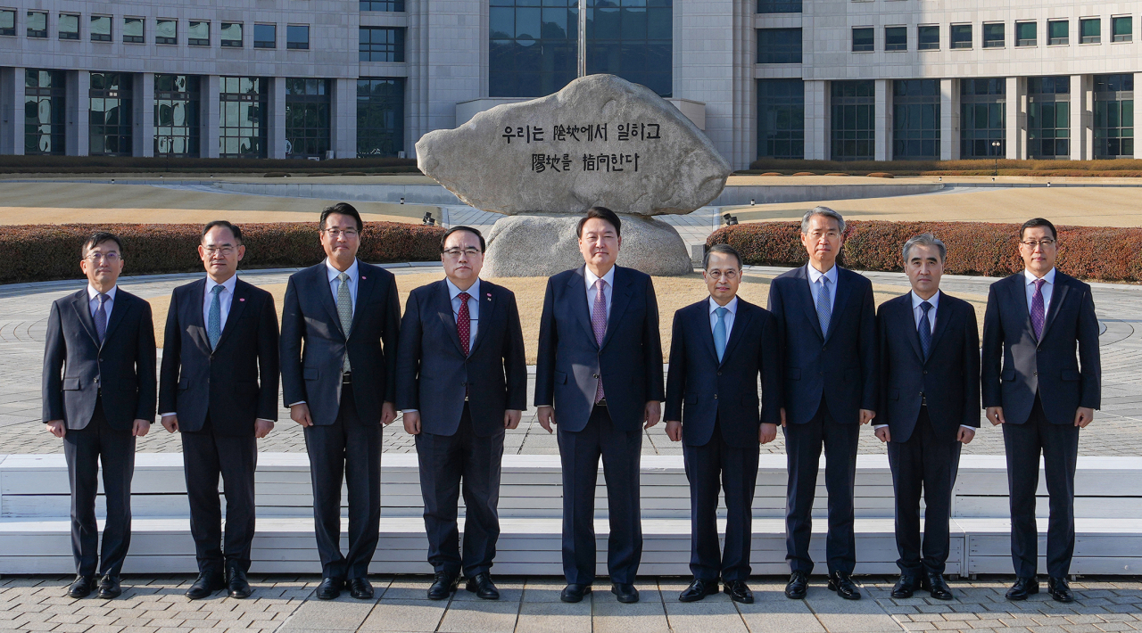 윤석열 대통령이 24일 국가정보원을 찾아 2023년도 업무계획을 보고받기에 앞서 국정원 원훈석 앞에서 간부들과 기념촬영을 하고 있다. [연합]