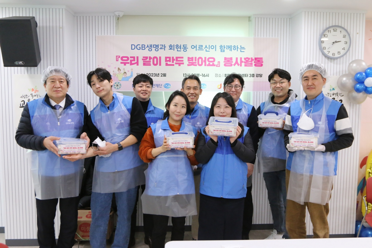 DGB생명 김성한 대표(맨 왼쪽)와 DGB생명 임직원들이 27일 회현동 주민센터에서 ‘만두 빚기 봉사활동’을 진행하며 기념사진을 촬영하고 있다. [DGB생명 제공]