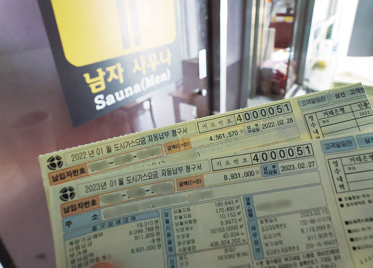 이달 14일 서울 성북구 한 대중목욕탕에서 업주가 올해 1월과 지난해 1월 도시가스 요금 고지서를 보여주고 있다. 업주는 비싸진 가스비에 놀라 작년 1월 고지서를 다시 찾아봤다며 요금이 폭탄 수준이라고 말했다. [연합]