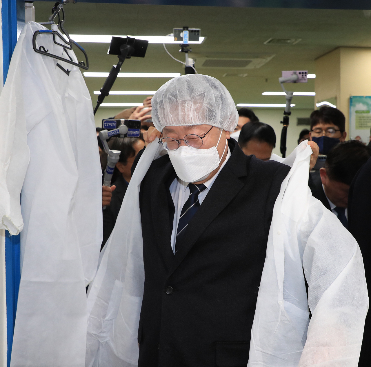 더불어민주당 이재명 대표가 28일 학교 급식실 노동자 폐암 진단과 관련해 서울 은평구 수색초등학교를 방문, 조리실을 둘러보기 전 위생복을 착용하고 있다. [연합]