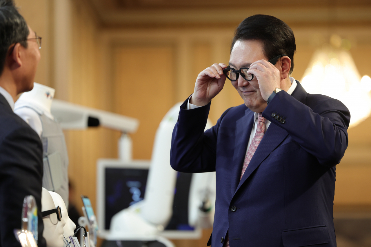 윤석열 대통령이 28일 청와대 영빈관에서 열린 바이오헬스 신시장 창출전략 회의에 앞서 뇌전증 감지 웨어러블 기기인 제로 글래스를 착용해 보고 있다. [연합]