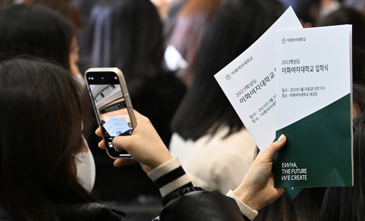 24일 서울 서대문구 이화여자대학교에서 2023학년도 입학식이 열린 가운데 한 입학생이 행사를 기다리며 팜플렛을 촬영하고 있다. 임세준 기자