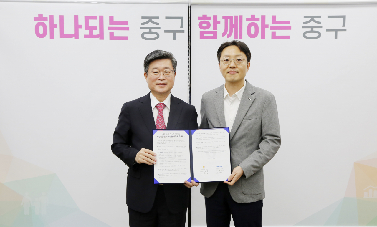 송석기(오른쪽) 두산 유통BU(비즈니스유닛) 상무와 김길성 중구청장이 지난달 28일 양사 간 업무협약을 체결한 뒤 기념촬영을 하고 있다. [두산 제공]