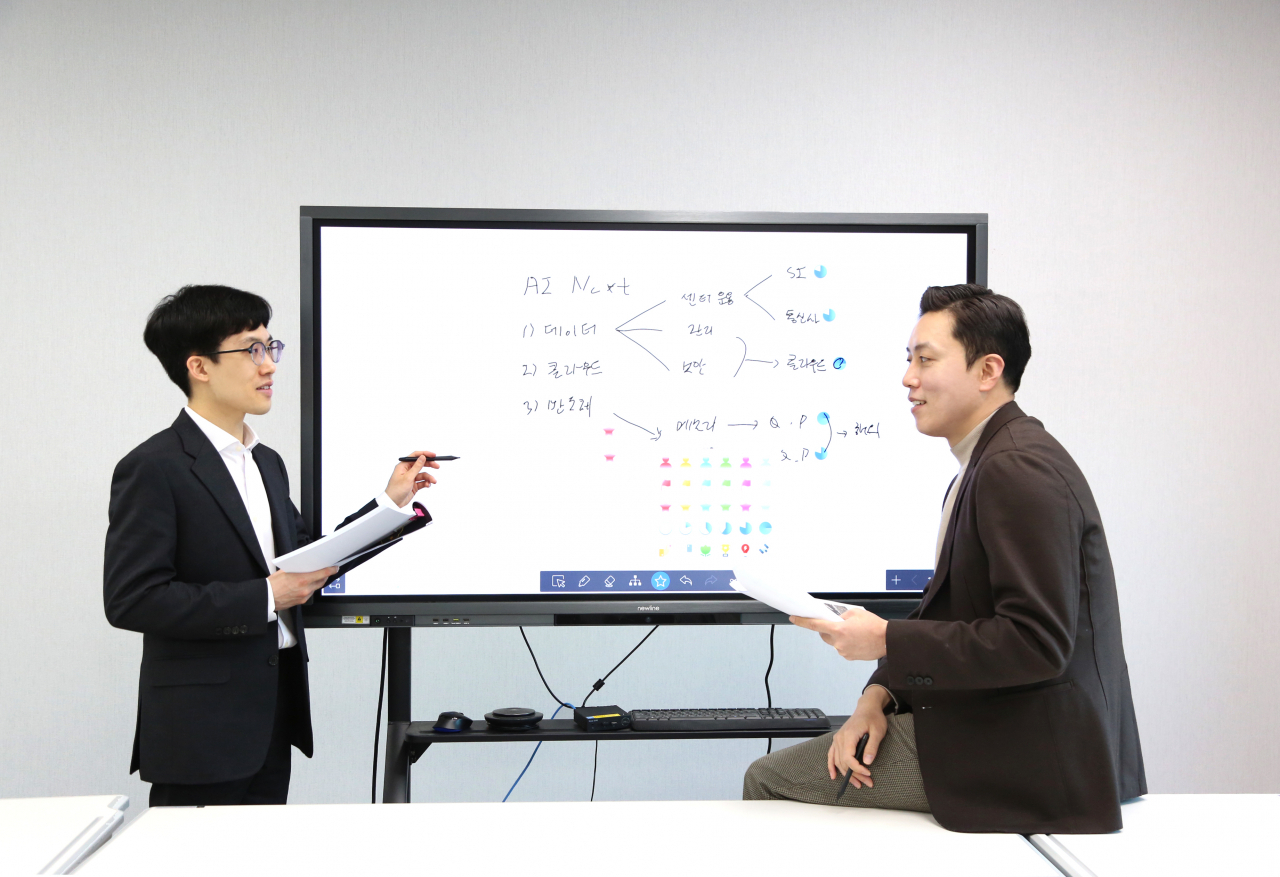 멘토인 오강호(오른쪽) 신한투자증권 수석연구원이 멘티인 작년 신규 입사직원 노승현 주임을 코칭하고 있다. [신한투자증권]