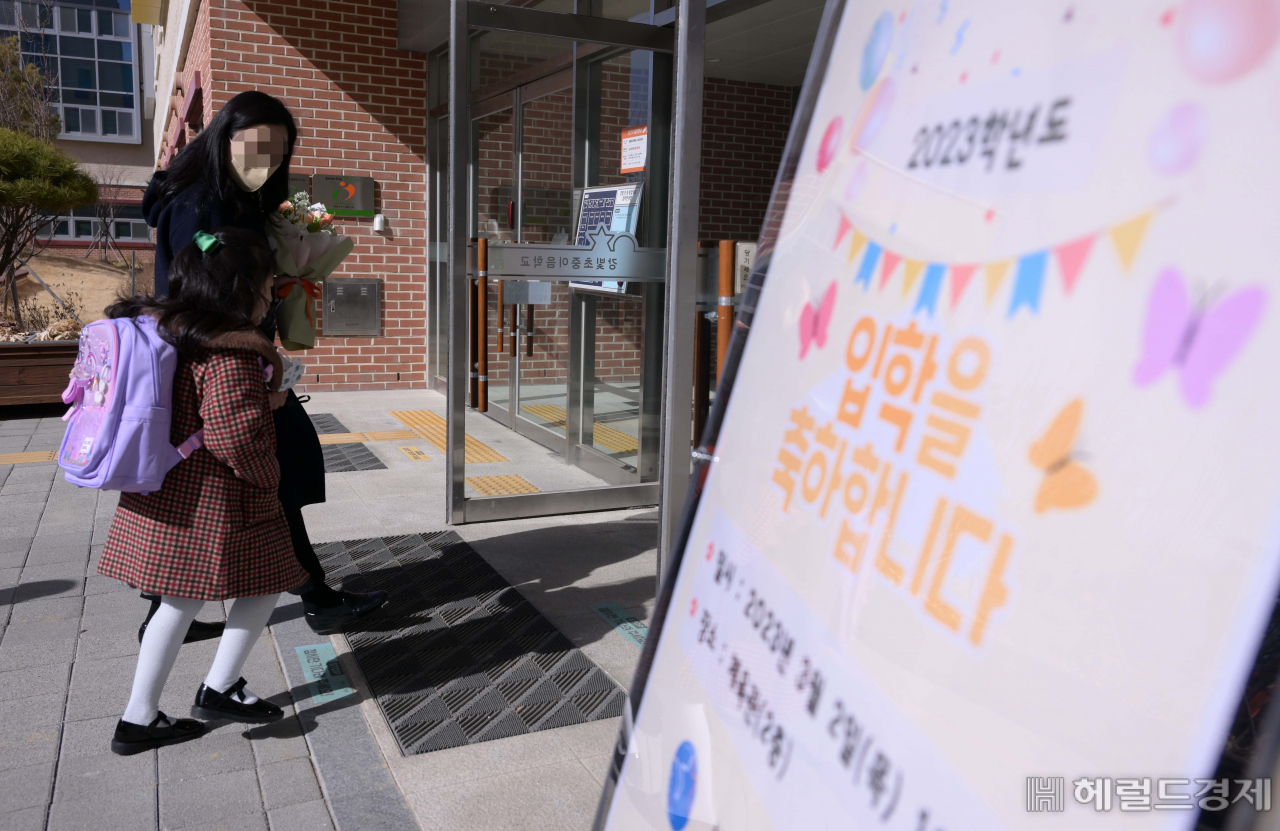 새학기가 시작된 2일 서울 강동구 강빛초등학교에서 신입생 입학식이 열린 가운데 한 신입생이 엄마와 함께 강당으로 들어가고 있다. 이상섭 기자