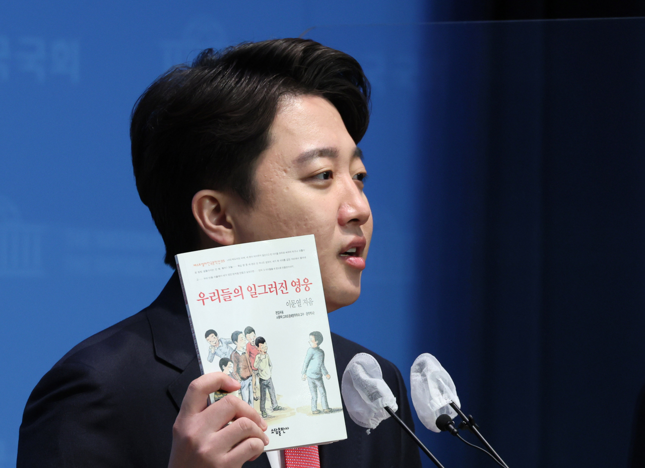 이준석 전국민의힘 대표가 3일 오전 국회 소통관에서 전당대회 등 현안 관련 기자회견을 하며 소설 '우리들의 일그러진 영웅'을 들어 보이고 있다. 이 대표는 소설 속 시골 학급의 모습이 최근 국민의힘의 모습과 닿아 있다고 꼬집었다. [연합]