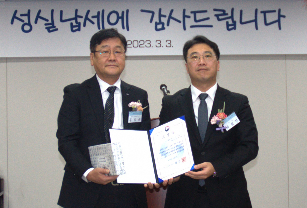 홍길준(왼쪽) LIG넥스원 경영관리본부장이 박성무 기흥세무서장으로부터 표창을 받고 기념촬영을 하고있다. [LIG넥스원 제공]