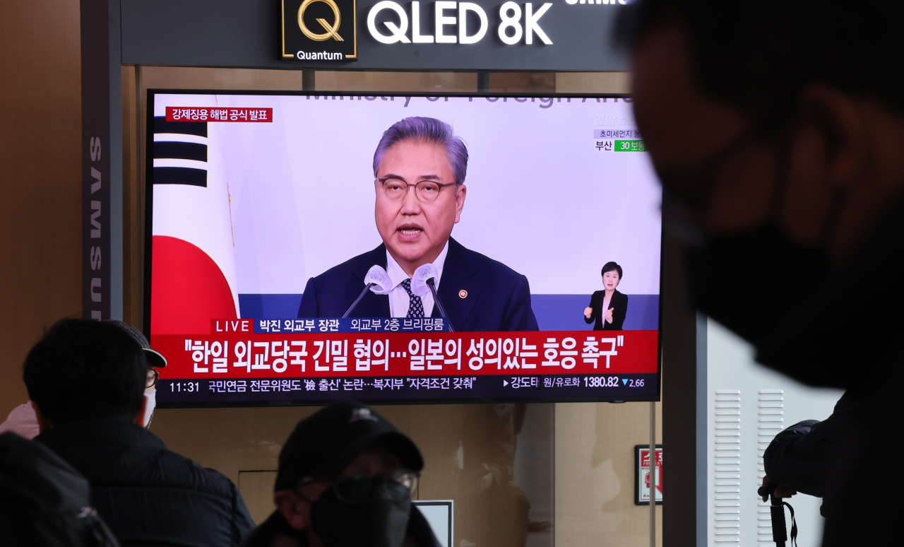 정부가 강제징용 배상 문제 해법안을 공식 발표한 6일 서울역 대합실에서 시민들이 관련 뉴스를 시청하고 있다. [연합]