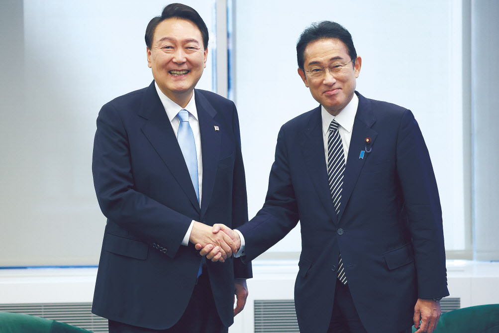 윤석열 대통령과 기시다 후미오(오른쪽) 일본 총리가 지난해 9월 21일(현지시간) 윤 대통령 취임 후 처음으로 미국 뉴욕에서 만나 악수를 하면서 밝게 웃고 있다.[연합]