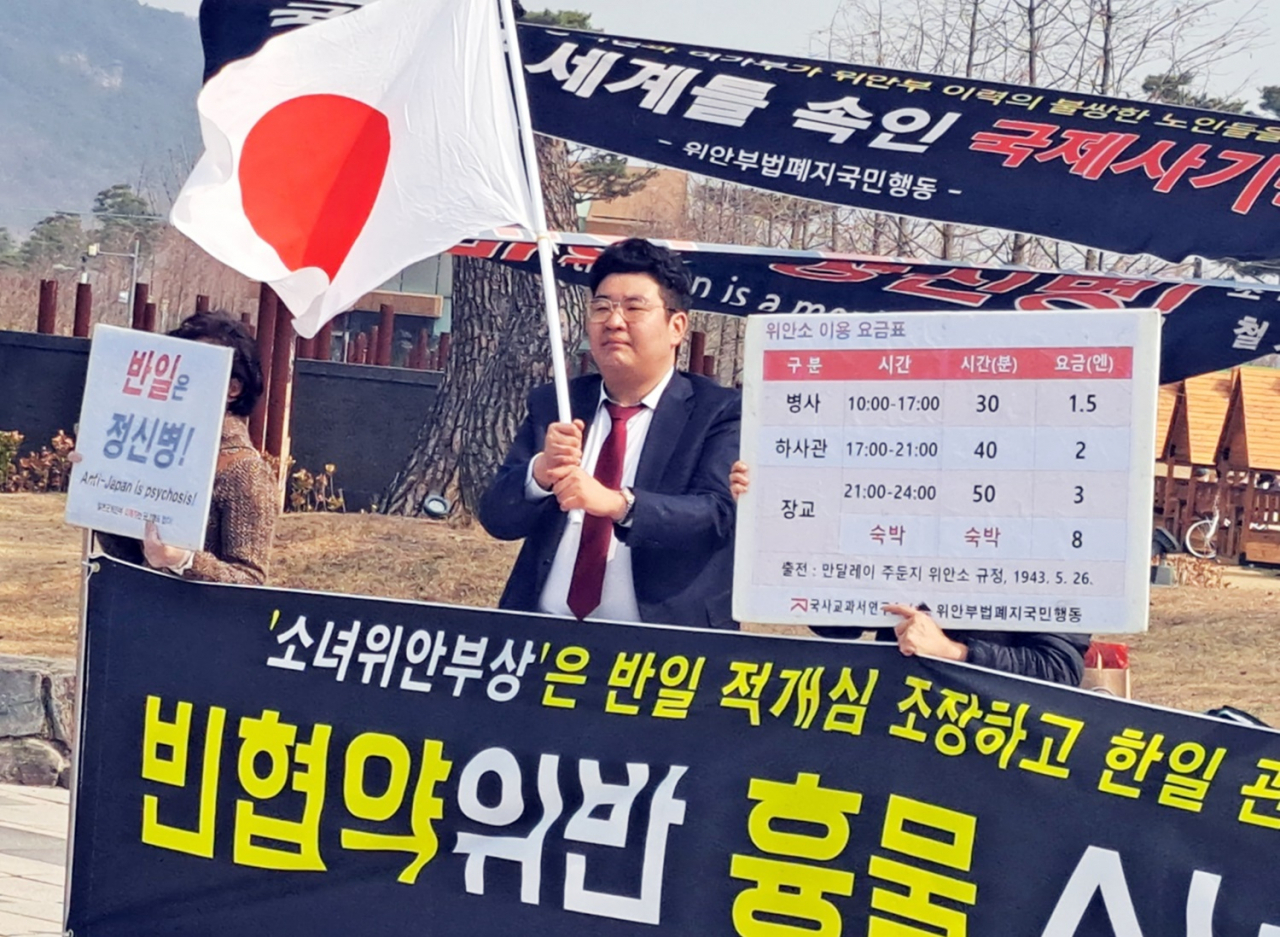 위안부법폐지국민행동 주최로 7일 세종호수공원 내 평화의 소녀상 앞에서 열린 소녀상 철거 촉구 집회에서 지난 3·1절에 세종시 한솔동 한 아파트 베란다에 일장기를 게양했던 시민이 일장기를 흔들고 있다. [연합]