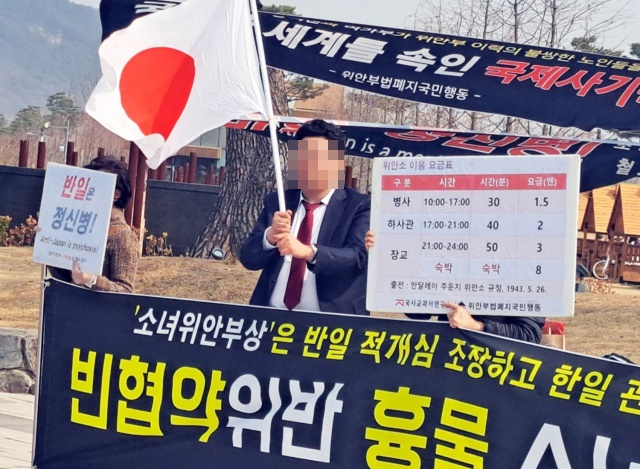 위안부법폐지국민행동 주최로 7일 세종호수공원 내 평화의 소녀상 앞에서 열린 소녀상 철거 촉구 집회에서 지난 3·1절에 세종시 한솔동 한 아파트 베란다에 일장기를 게양했던 이정우 씨가 일장기를 흔들고 있다. [연합]