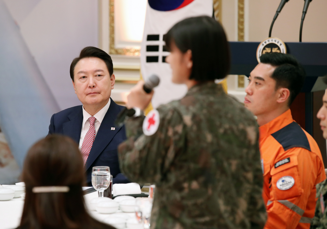 윤석열 대통령이 7일 청와대 영빈관에서 열린 튀르키예 지진 대응 대한민국 해외긴급구호대 격려 오찬에서 국군수도병원 이인우 대위의 소감발표를 경청하고 있다. [연합]