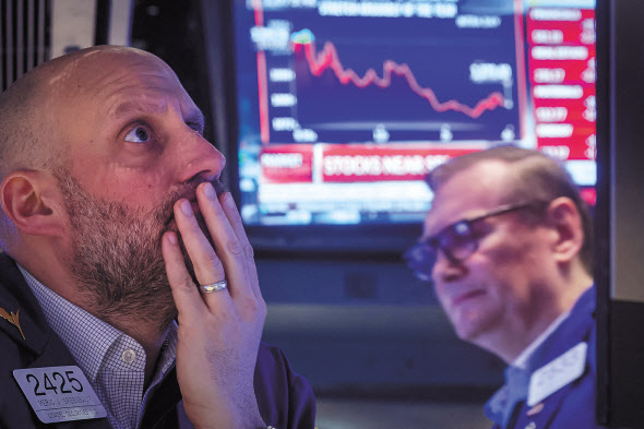 뉴욕증권거래소(NYSE)의 증권 거래인들이 7일(현지시간) 방송으로 중계된 제롬 파월 연방준비제도(Fed) 의장의 상원 청문회 발언을 주시하며 긴장된 표정으로 증시 동향을 확인하고 있다. 이날 지속적인 금리 인상과 통화긴축 정책을 시사한 파월 의장의 매파적 발언으로 주요 지수가 일제히 하락했다. [로이터]