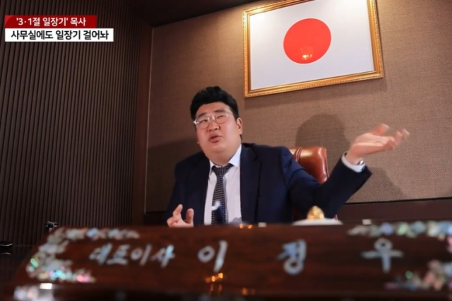 3·1절에 일장기를 내걸어 논란이 됐던 이정우 목사가 자신의 사무실에서 인터뷰를 하고 있는 모습. 그의 사무실에는 일장기 외에 태극기를 걸어둔 곳도 있다. [YTN 보도화면 캡처]