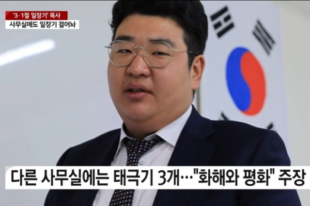 3·1절에 일장기를 내걸어 논란이 됐던 이정우 목사가 자신의 사무실에서 인터뷰를 하고 있는 모습. 그의 사무실에는 일장기 외에 태극기를 걸어둔 곳도 있다. [YTN 보도화면 캡처]