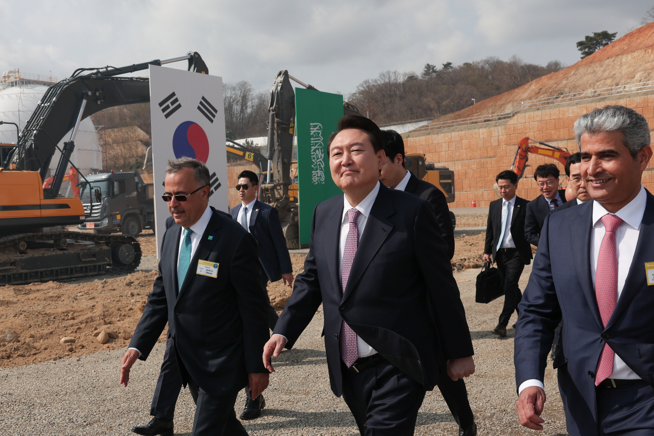 윤석열 대통령이 9일 울산광역시 울주군 온산국가산업단지에서 열린 에쓰오일(S-OIL) 샤힌 프로젝트 기공식을 마친 뒤 후세인 알 카타니 에쓰오일 CEO(오른쪽),아민 나세르 아람코 CEO와 함께 현장을 나서고 있다. 샤힌 프로젝트는 에쓰오일이 추진하는 울산 2단계 석유화학 프로젝트다. 에쓰오일은 9조3000억원을 들여 울산 온산국가산업단지 내에 스팀 크래커를 비롯한 대단위 석유화학 생산 설비를 건설할 계획이다. [연합]