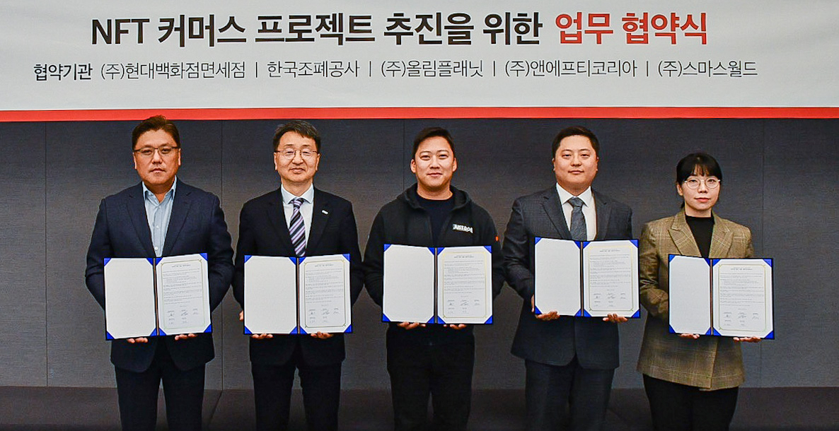현대백화점면세점이 서울 강남구 삼성동 파르나스타워 올림플래닛 본사에서 한국조폐공사·스마스월드·올림플래닛·앤에프티코리아와 함께 ‘NFT 커머스 프로젝트’ 추진을 위한 다자간 업무협약(MOU)을 체결했다. 왼쪽부터 육우석 현대백화점면세점 마케팅담당 상무·임도현 한국조폐공사 ICT 이사·권재현 올림플래닛 대표·임종령 앤에프티코리아 대표·허현 스마스월드 대표. [현대백화점면세점 제공]