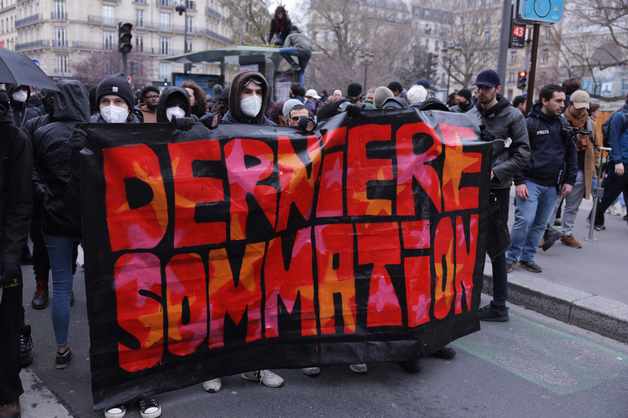 Protesters hold a banner reading