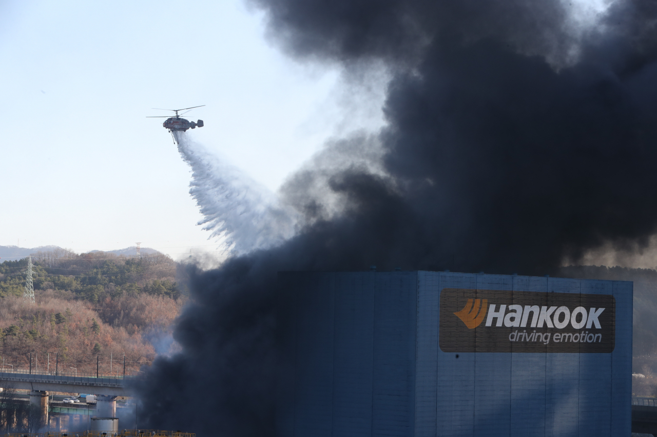 13일 오전 대전 대덕구 목상동 한국타이어 공장 화재를 진압 중인 헬기가 화재 현장 상공에서 물을 뿌리고 있다. [연합]