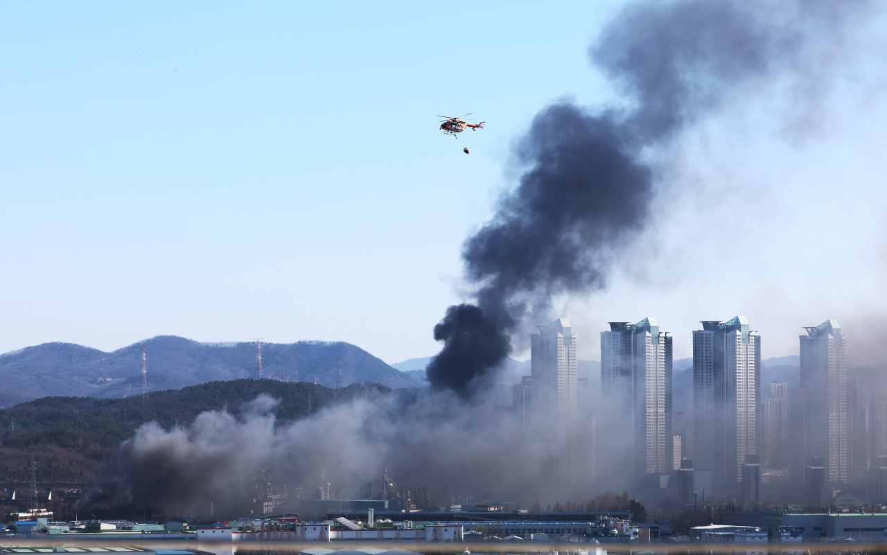 13일 오전 대전시 대덕구 목상동 한국타이어 공장에서 난 불로 인한 연기가 공중으로 치솟고 있다. 소방헬기가 연신 물을 뿌리며 진화작업을 펼치고 있다. [연합]