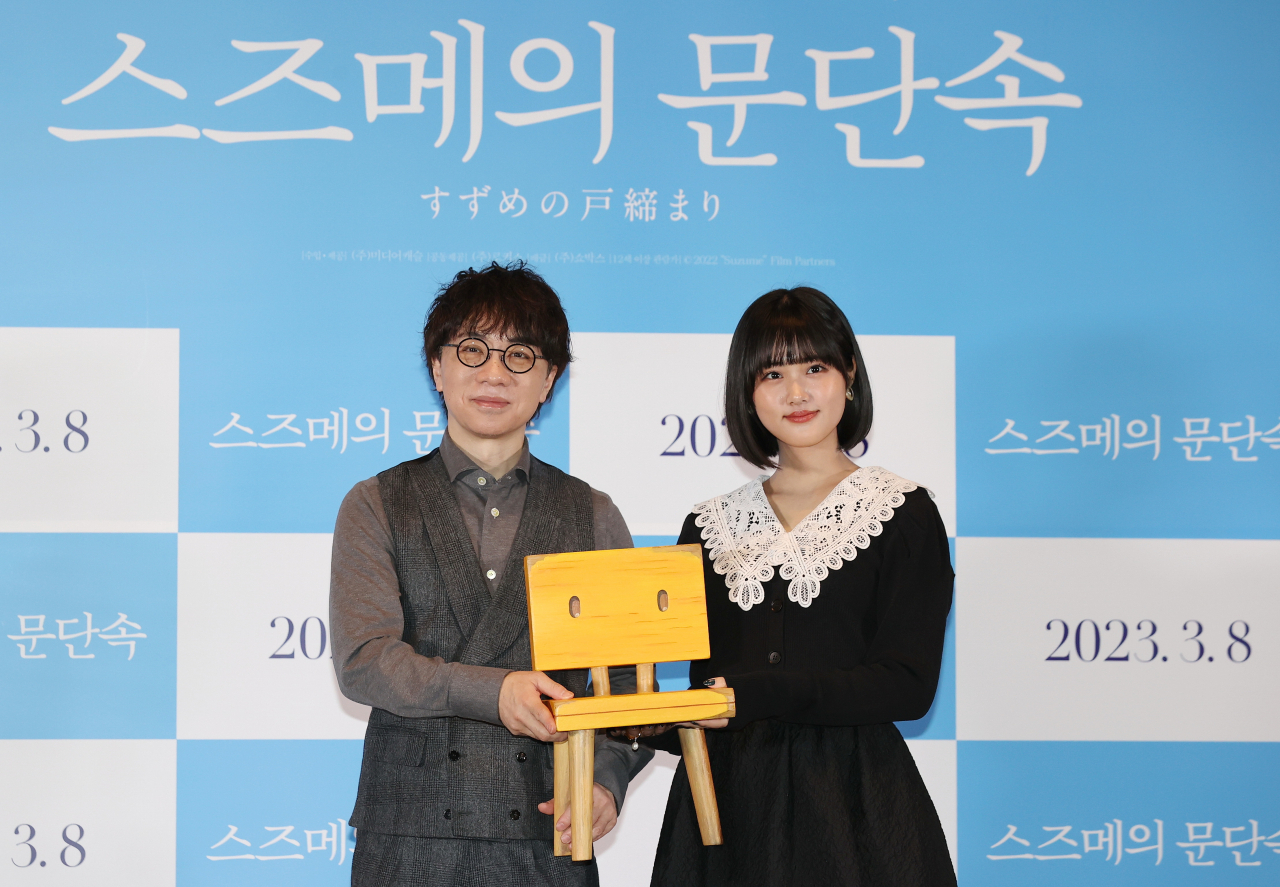 지난 8일 오전 서울 성동구 메가박스 성수점에서 열린 일본 애니메이션 '스즈메의 문단속' 기자회견에서 신카이 마코토 감독(왼쪽)과 주인공 '스즈메'역을 맡은 배우 하라 나노카가 극 중 출연 캐릭터를 들고 포즈를 취하고 있다. [연합]
