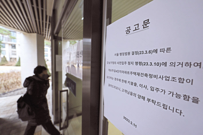 13일 입주가 중단된 서울 강남구 개포동 ‘개포자이 프레지던스(개포주공 4단지 재건축)’아파트단지(왼쪽). 소송 문제로 서울 강남 개포자이프레지던스의 입주 중단을 하루 앞둔 12일 오후 단지 내 입주지원센터에 관련 공고문이 붙어 있다. [연합]