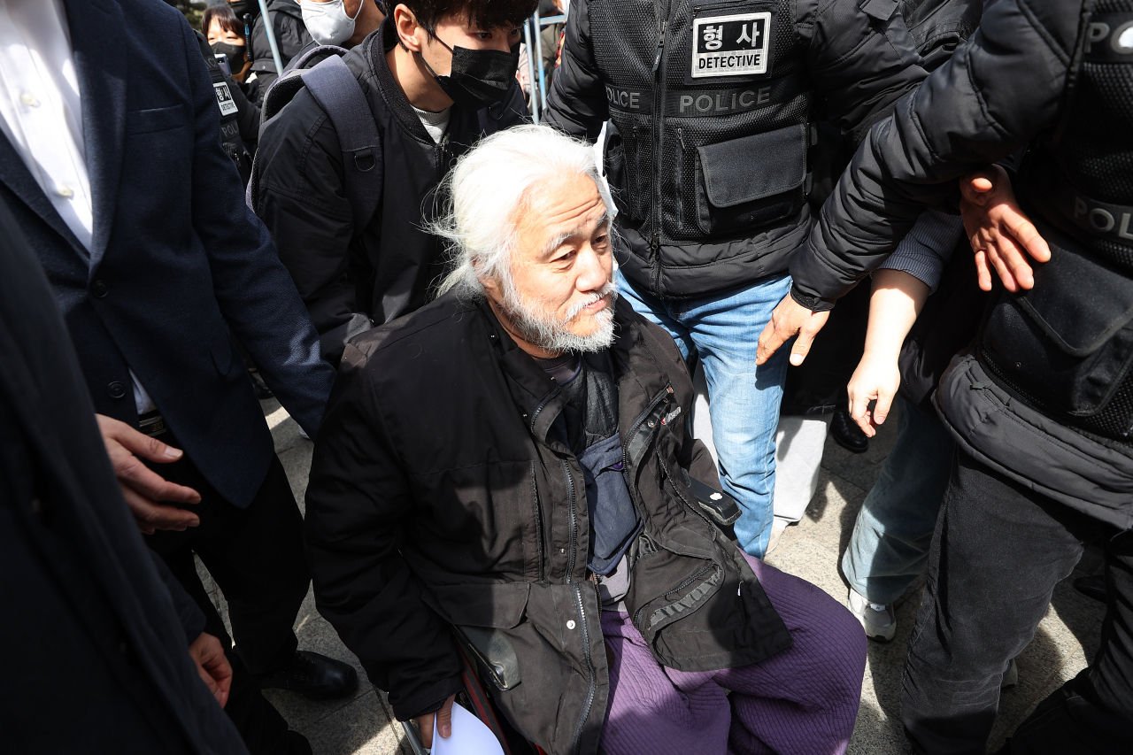 박경석 전국장애인차별철폐연대(전장연) 상임공동대표가 17일 오전 서울 종로구 서울경찰청 앞에서 기자회견을 마친 뒤 서울 남대문경찰서로 향하는 호송차량으로 이동하고 있다 . [연합]
