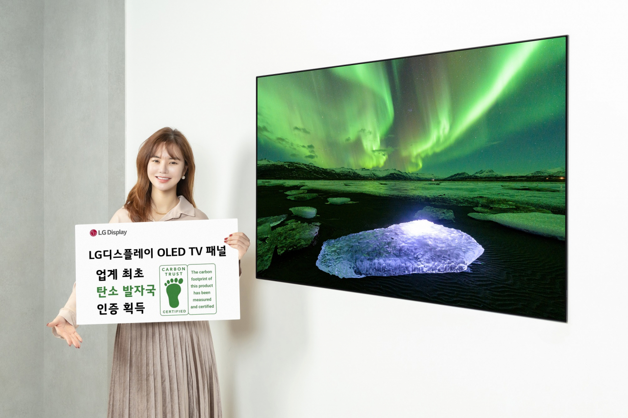 LG디스플레이 모델이 카본 트러스트 인증서와 OLED TV 패널을 소개하는 모습.[LG디스플레이 제공]
