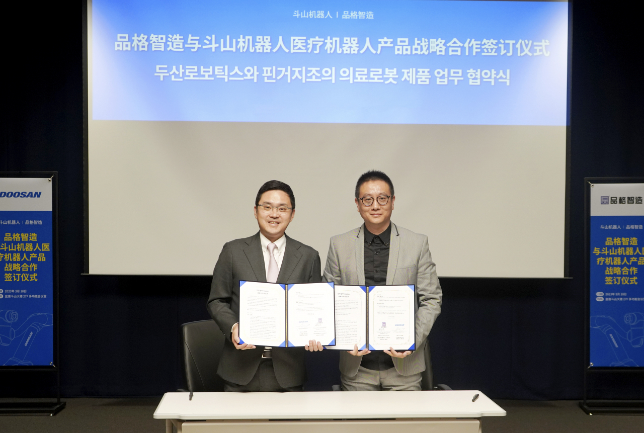 류정훈(왼쪽) 두산로보틱스 대표와 량즈훙 핀거지조 대표가 협약을 맺고 기념사진을 촬영하고 있다. [두산 제공]