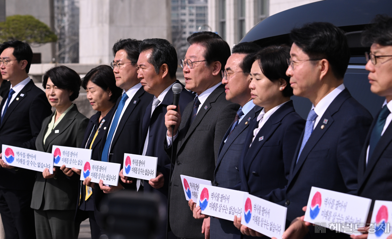 더불어민주당 대일굴종외교 규탄 태극기달기 운동 행사가 22일 서울 영등포구 여의도 국회 본청 앞에서 열려 이재명 대표를 비롯한 지도부가 참석해 기자회견 및 태극기 부착행사를 진행하고 있다. 임세준 기자