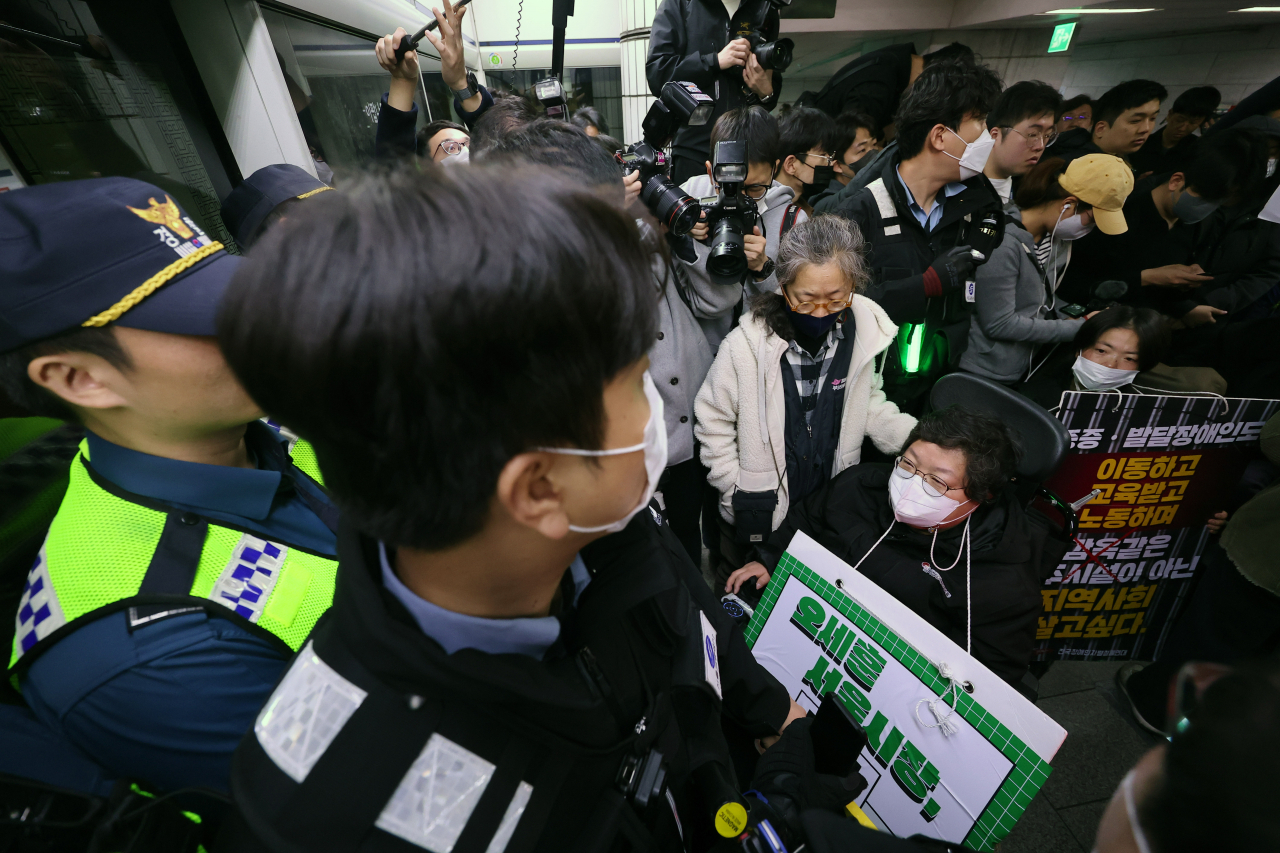 23일 오전 서울 시청역에서 전국장애인차별철폐연대(전장연) 회원들이 장애인권리예산 등을 촉구하는 기자회견을 하고 지하철 탑승을 시도하다 경찰, 서울교통공사 관계자들과 대치하고 있다. [연합]