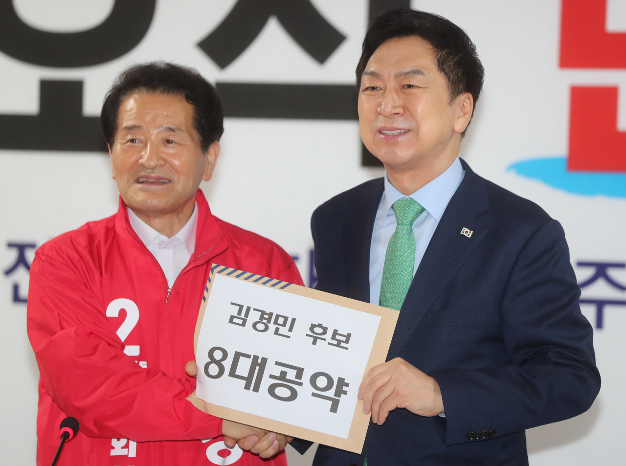 김기현 국민의힘 대표(오른쪽)가 23일 전북 전주시 완산구 김경민 전주을 국회의원 재선거 후보 선거사무소에서 열린 국민의힘 전북 현장 최고위원회의에서 김 후보로부터 8대 공약이 적힌 서류를 받은 뒤 기념 촬영을 하고 있다. [연합]