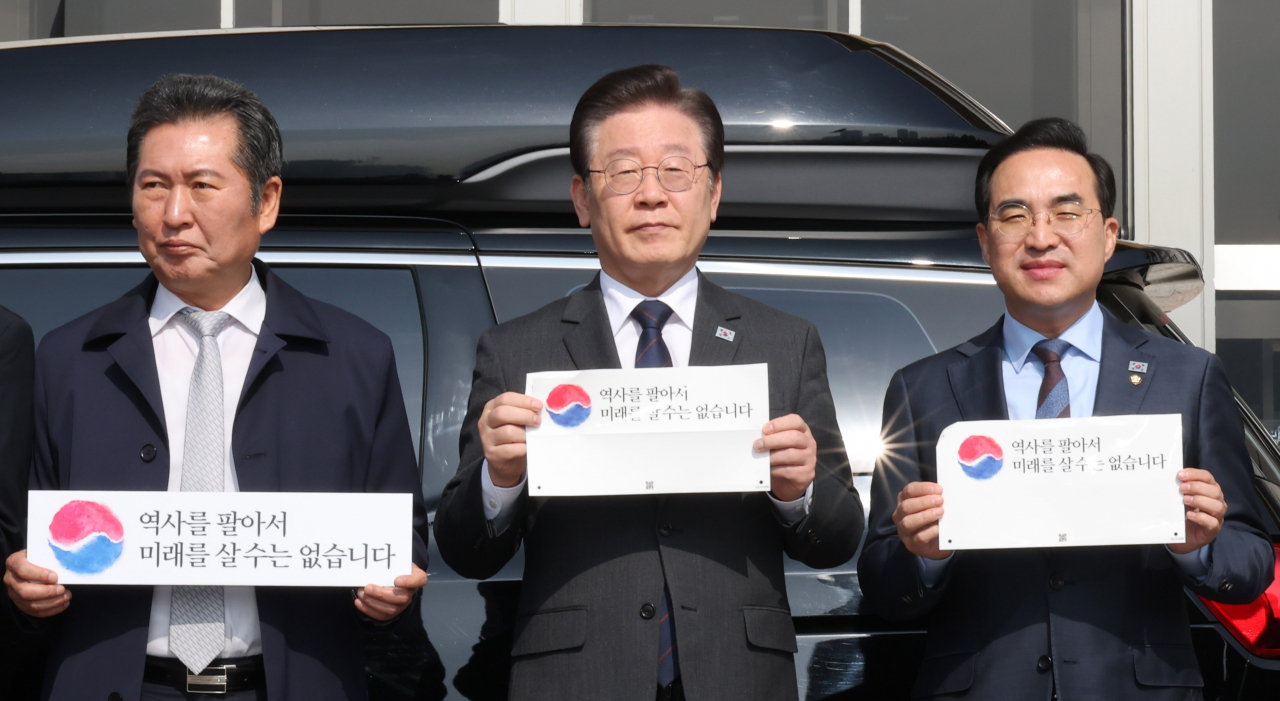 더불어민주당 이재명 대표가 22일 오전 서울 여의도 국회 본청 앞에서 열린 대일굴종외교 규탄 태극기달기 운동 행사에서 태극기 스티커를 들고 포즈를 취하고 있다. [연합]