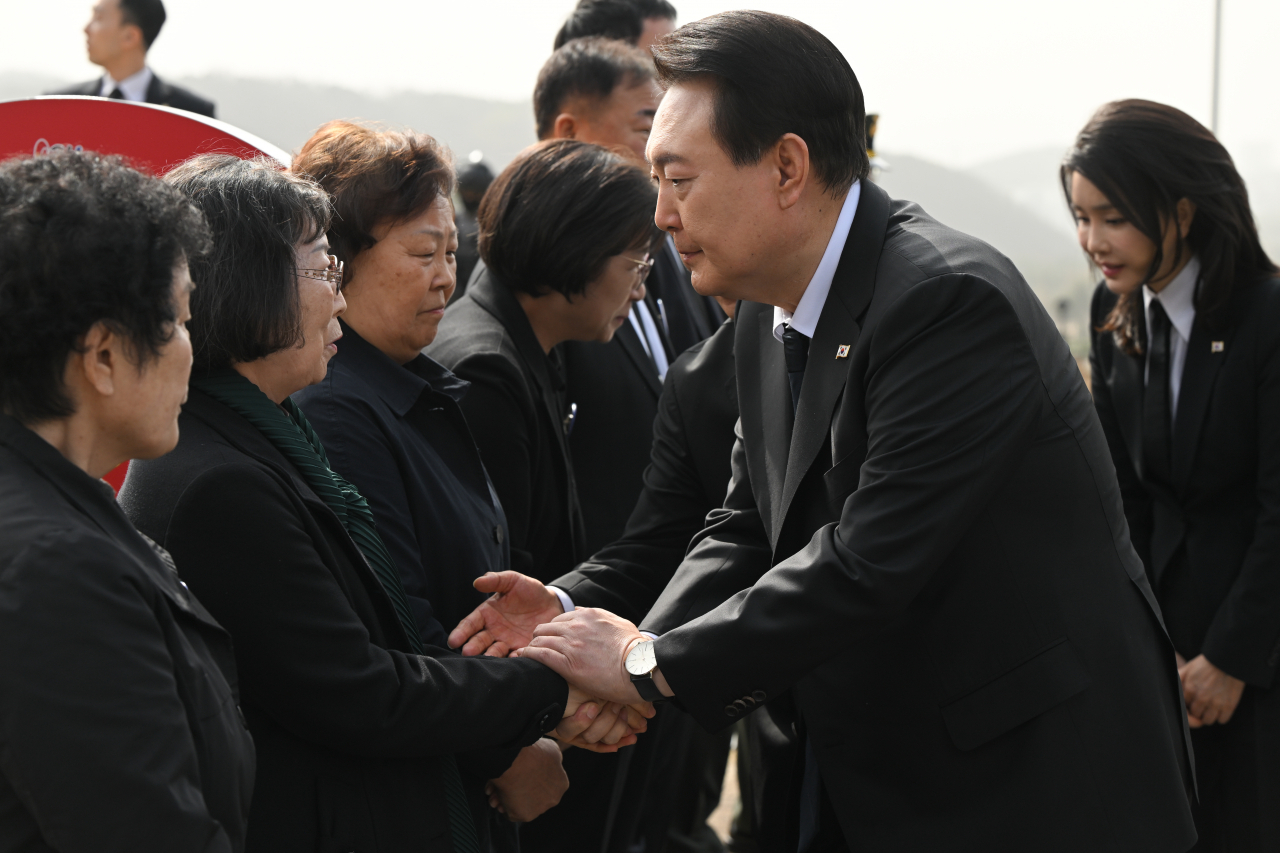윤석열 대통령과 김건희 여사가 24일 대전 유성구 국립대전현충원에서 열린 제8회 서해수호의 날 기념식에 앞서 제2연평해전 및 연평도 포격전 전사자 묘역을 참배하며 유족과 인사하고 있다. [연합]
