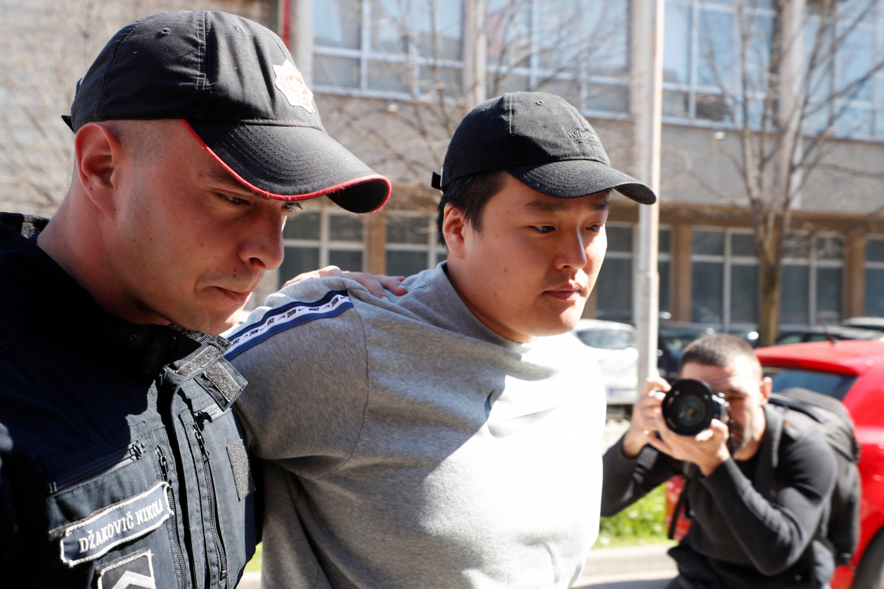권도형 테라폼랩스 대표가 24일(현지시간) 몬테네그로 수도 포드고리차에서 경찰관에게 이끌려 법원으로 향하고 있다. [로이터]