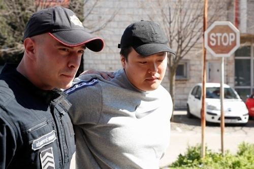 권도형 테라폼랩스 대표가 24일(현지시간) 몬테네그로 수도 포드고리차에서 경찰관에게 이끌려 법원으로 향하고 있다. [로이터]