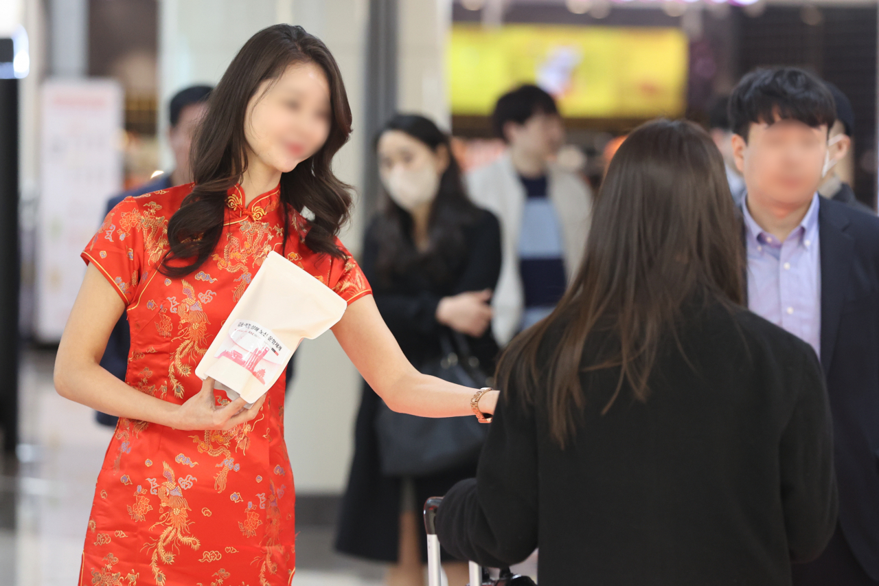 코로나19로 중단됐던 김포-북경·상해 노선 운항이 재개된 가운데 27일 오후 한국공항공사 관계자들이 김포공항에서 김포-북경·상해 노선 운항 재개를 기념해 승객들에게 기념품을 나눠주고 있다. [연합]
