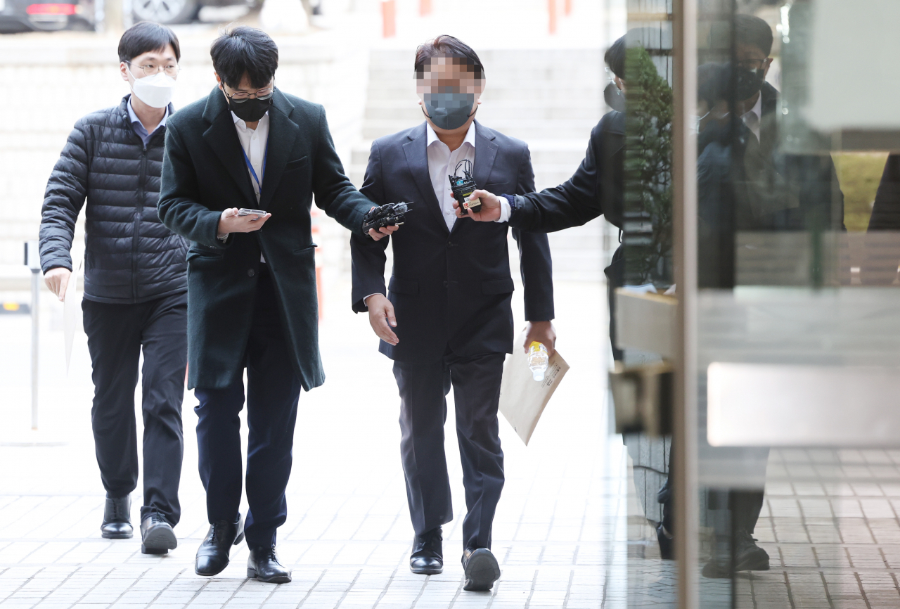 '백현동 개발 비리 의혹'과 관련 로비스트 역할을 한 것으로 지목된 김인섭 전 한국하우징기술 대표의 측근으로 알려진 사업가 김모씨(사진 가운데)가 27일 서울중앙지법에서 열리는 영장심사에 출석하는 모습. 김씨에 대한 구속영장 청구는 기각됐다. [연합]