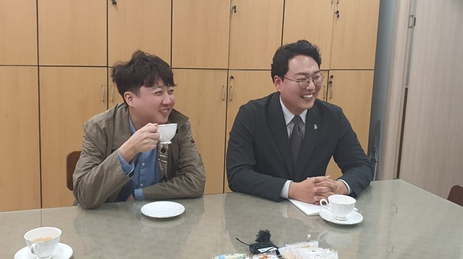 이준석·천하람 두 사람이 29일 통역 자원봉사자 명단에 이름을 올리고 상대방과 이야기를 나누고 있다.