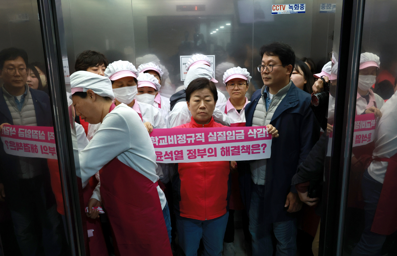 31일 총파업을 앞둔 전국학교비정규직노조 박미향 위원장(가운데)과 조합원들이 30일 오전 서울 영등포구 한국교육시설안전원 회의실에서 '정부·시도 교육청의 집단교섭 해법 제시, 학교급식실 종사자의 폐암 관련 대책'등을 요구하며 기습 펼침막 시위를 벌인 뒤 이주호 사회부총리 겸 교육부 장관과 면담이 이뤄지지 않자 회의장을 떠나고 있다. 이 회의실에서는 이주호 사회부총리 겸 교육부 장관 주재로 제1차 교원역량혁신 추진위원회 회의가 열릴 예정이었다. 이 부총리는 위원회 회의 시작 시간인 10시까지 회의 장소에 모습을 드러내지 않았다. [연합]