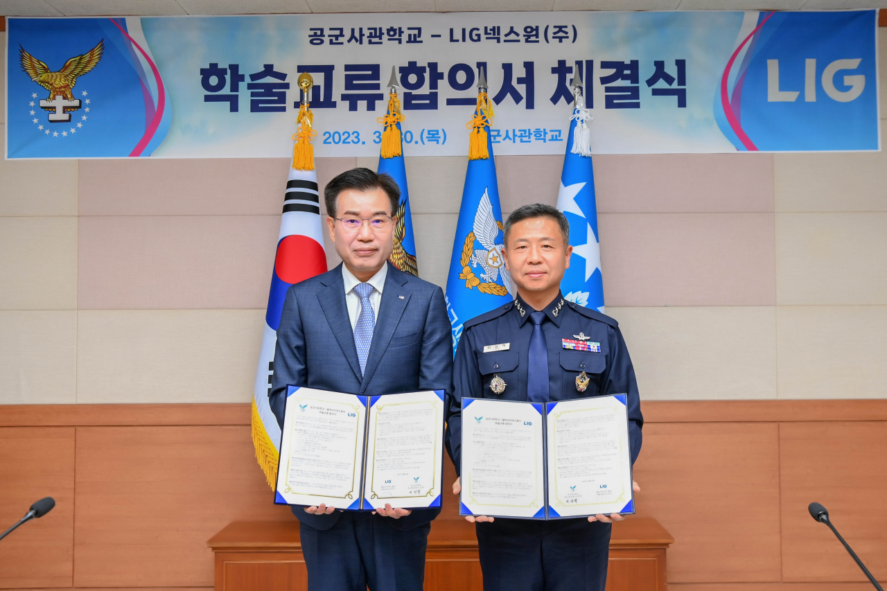 이건혁(왼쪽) LIG넥스원 PGM사업부문장과 이상학 공군사관학교장이 학술교류 합의서를 들고 기념 촬영을 하고 있다. [LIG넥스원 제공]