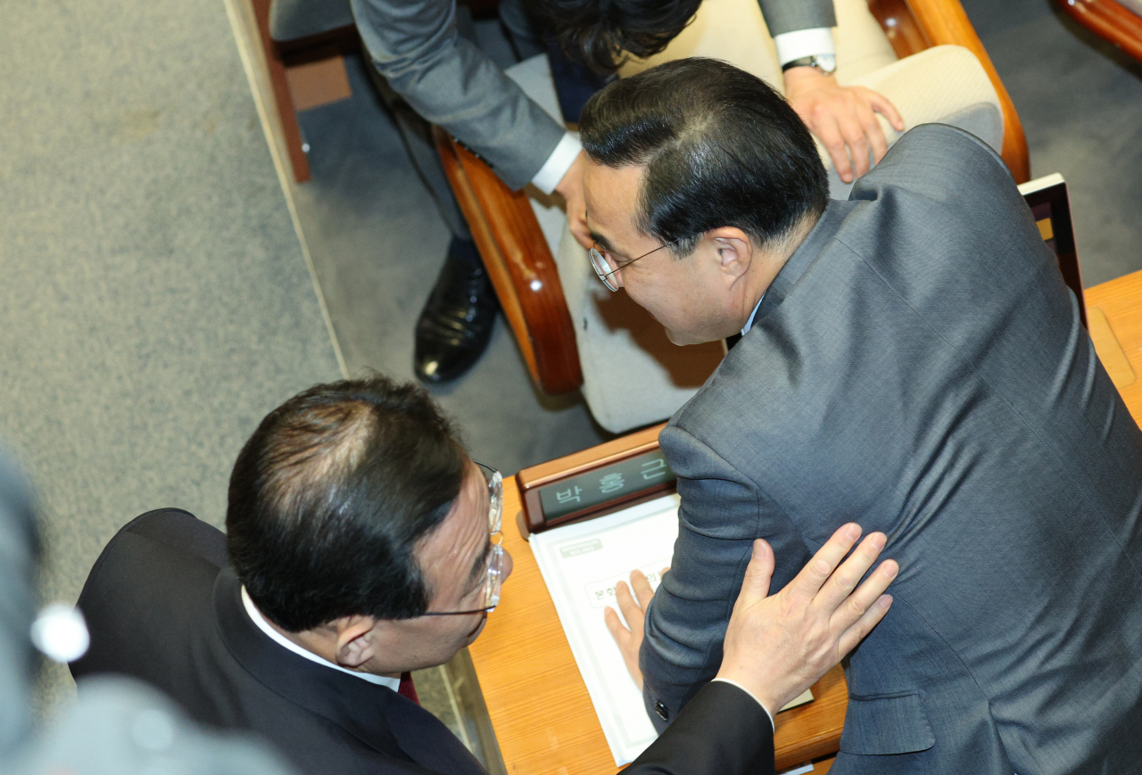30일 오후 국회 본회의장에서 열린 국회의원 선거제도 개선에 관한 결의안 심사를 위한 전원위원회 첫 회의에서 주호영 국민의힘 원내대표(왼쪽)와 박홍근 더불어민주당 원내대표가 대화하고 있다. 연합뉴스
