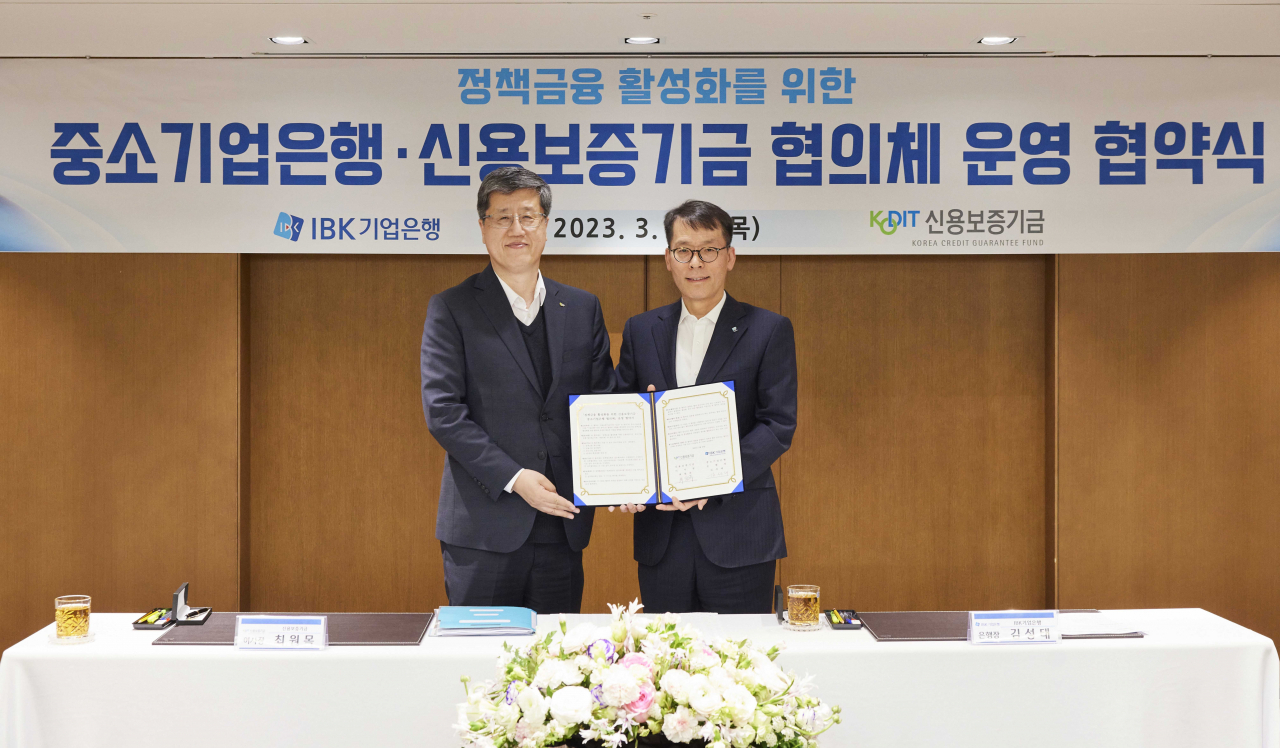 지난 30일 서울 을지로 기업은행 본점에서 열린 ‘정책금융 활성화를 위한 중소기업은행․신용보증기금 협의체 운영 협약식‘에서 김성태 IBK기업은행장(오른쪽)과 최원목 신용보증기금 이사장(왼쪽)이 기념 촬영을 하고 있다.[IBK기업은행 제공]