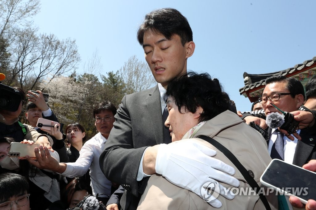 전직 대통령 고(故) 전두환 씨의 손자 전우원 씨가 31일 오전 광주 북구 운정동 국립 5·18민주묘지에서 5·18 유가족인 김길자 씨를 위로하고 있다.[연합]