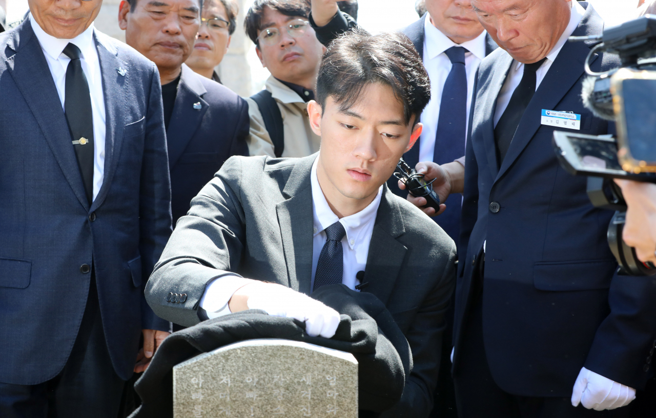 전직 대통령 고(故) 전두환 씨의 손자 전우원 씨가 31일 오전 광주 북구 운정동 국립 5.18 묘지 내 1묘역 고 김경철 열사 묘비를 닦고 있다. 연합뉴스